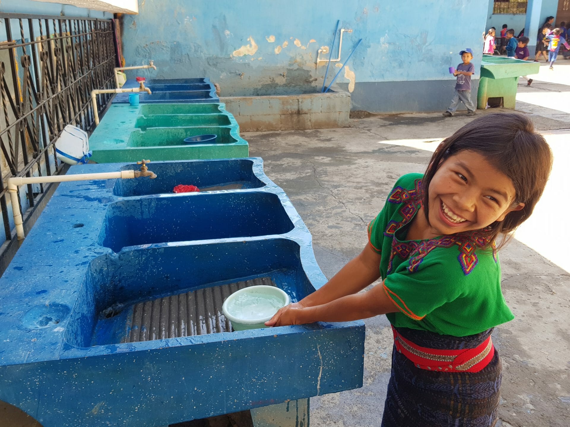 girl washing dishes smiling